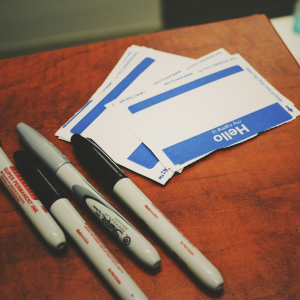 name tags and markers on a wooden table