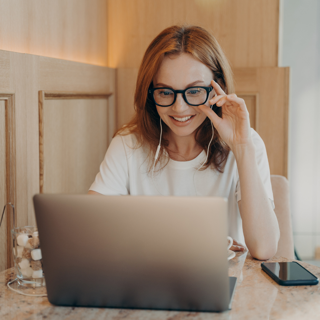 Woman sitting at desk looking at laptop 