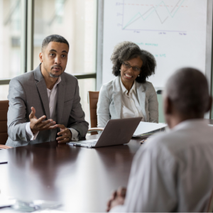 Three people sitting at board table