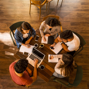 Picture of five colleagues meeting at round table