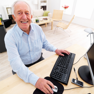 Senior man sitting at desk working on computer