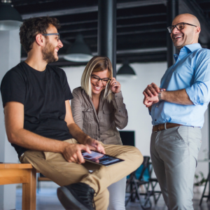 Three work colleagues standing and laughing together