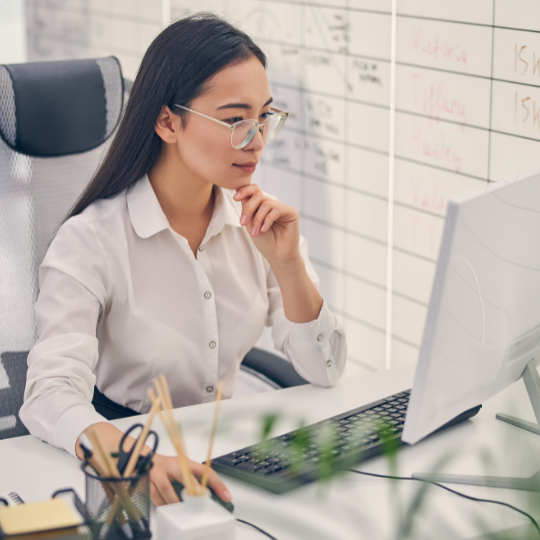 Woman sitting at desk and looking at computer screen 