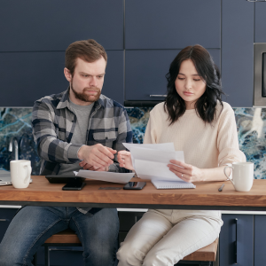 Picture of couple sitting at desk looking at letter