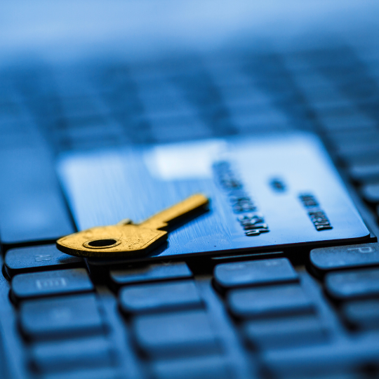 Picture of keyboard with credit card laying on it with a key on the top