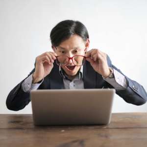 Man looking at laptop screen with a surprised look on his face