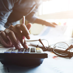 Picture of woman's hand holding a pencil and working on calculator